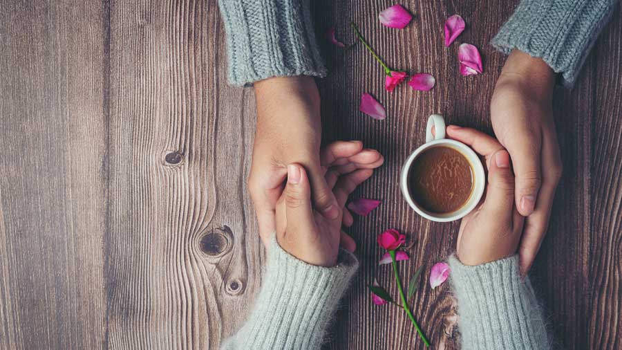 Mains chaleureuses qui se rejoignent autour d'une tasse de chocolat chaud